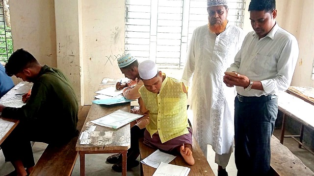 দুই হাত নেই, পা দিয়ে লিখে আলিম পরীক্ষা দিচ্ছে রাসেল